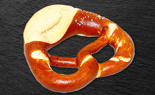 Fertig gebackene Laugenbrezel auf Schiefertafel