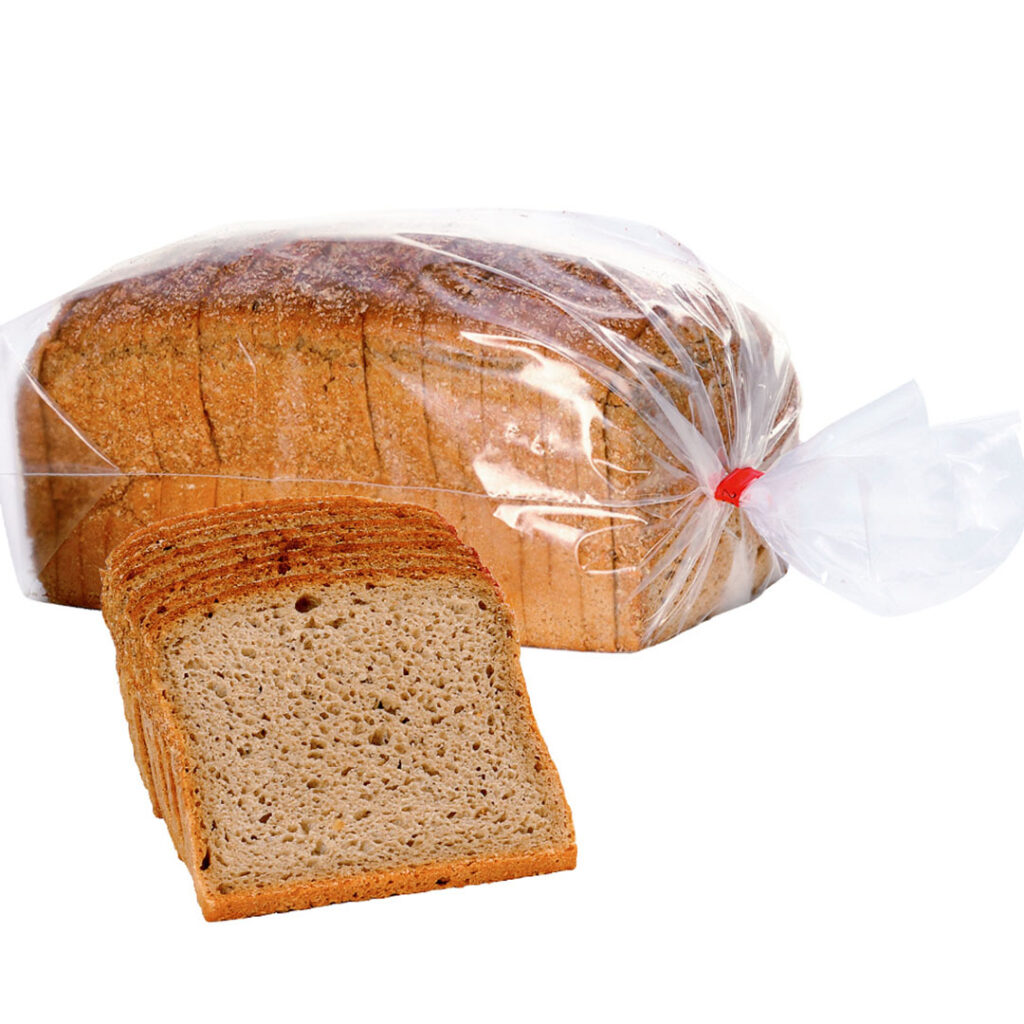 Ein frisches Roggenmischbrot, verpackt in einer klaren Plastiktüte, mit einer Scheibe Brot daneben.